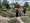 Fünf Personen stehen auf einem Kiesweg in einem Garten, umgeben von Lavendelsträuchern und Bäumen. Im Hintergrund ist ein Brunnen und ein blauer Himmel zu sehen. Die Gruppe posiert gemeinsam für ein Foto.