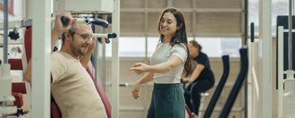 eine Frau unterstützt einem Mann beim Sport machen 